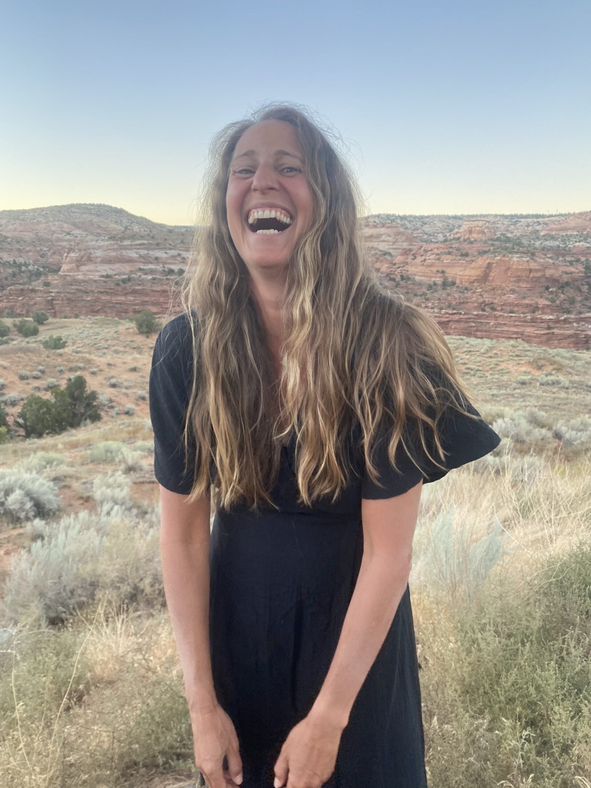 Meredith laughing in a red rock landscape